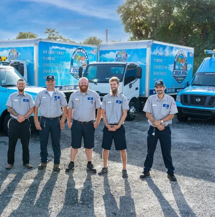 Space Coast Cooling & Plumbing team standing in front of service vehicles.