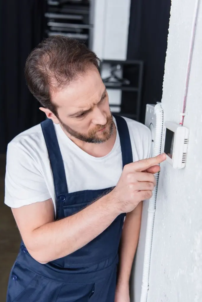 Technician inspecting a recently installed thermostat.