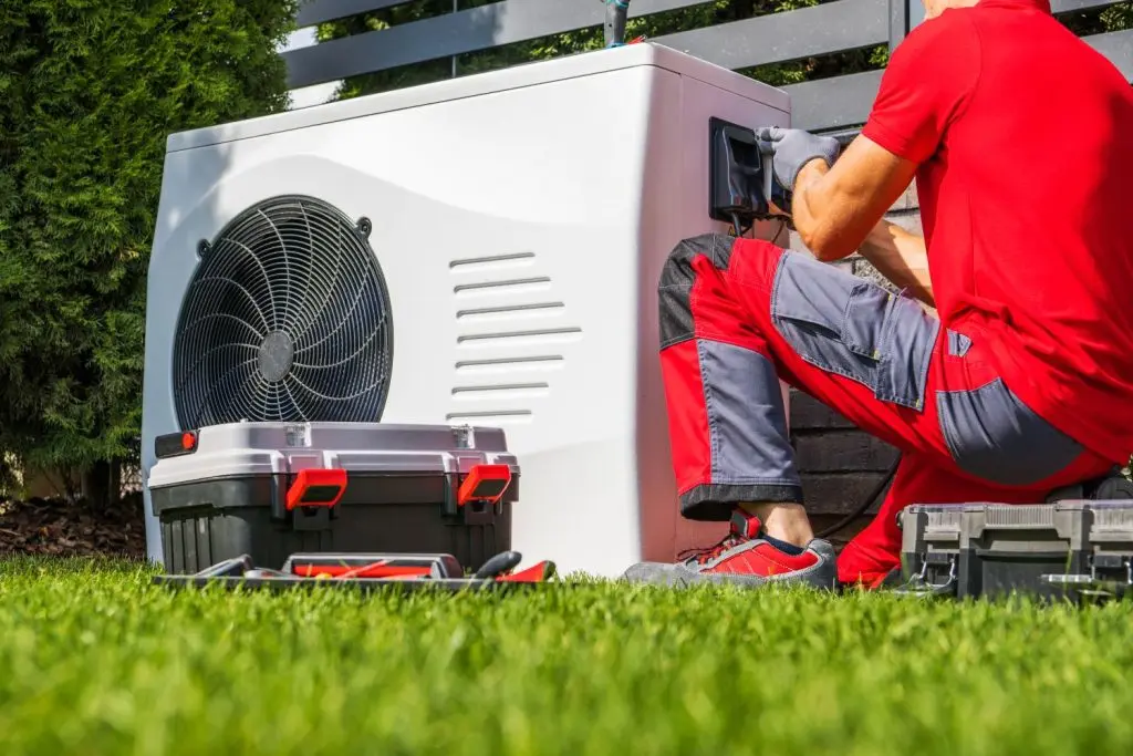 Technician repairing the outdoor unit of a heat pump.