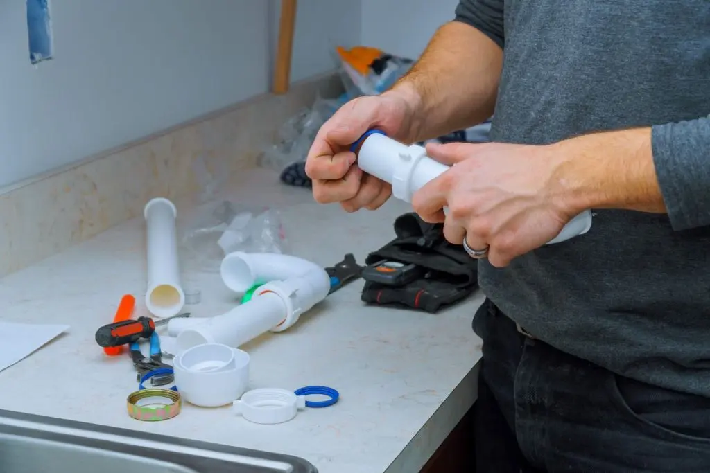 Plumber fitting new pipes to perform a repair