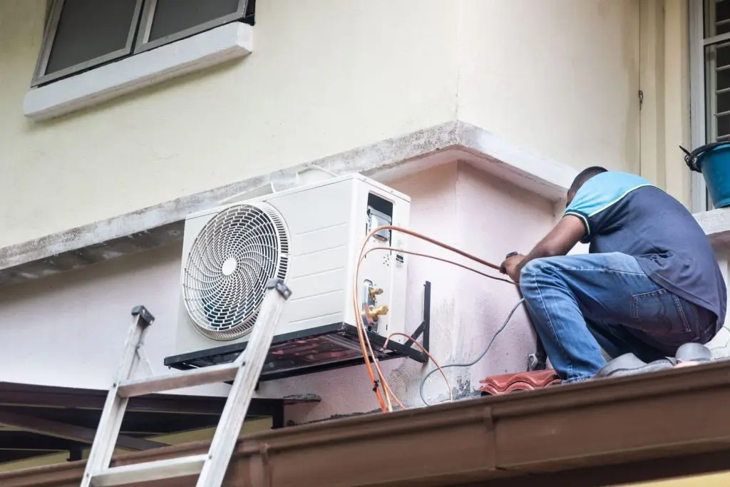 Technician repairing an AC unit.