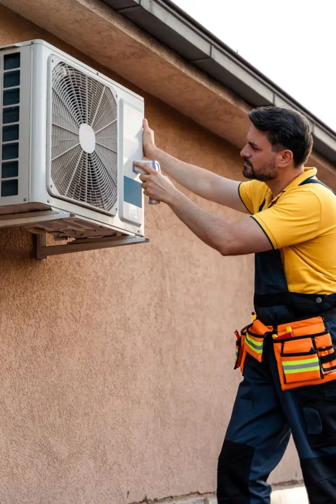 Technician inspecting an AC unit during maintenance service.