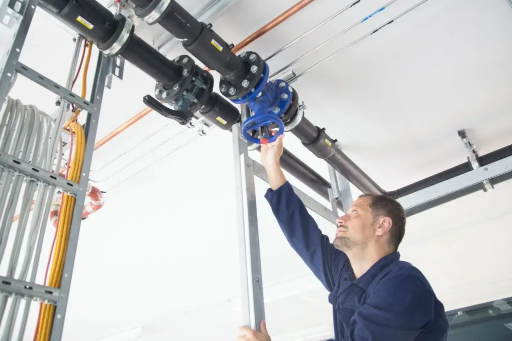 Plumber checking commercial pipes.