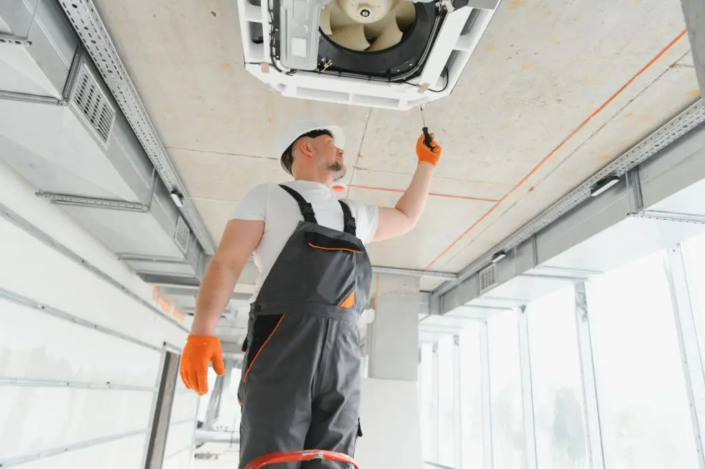 Worker repairing an AC unit.