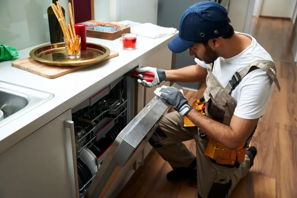 Plumber installing a dishwasher.